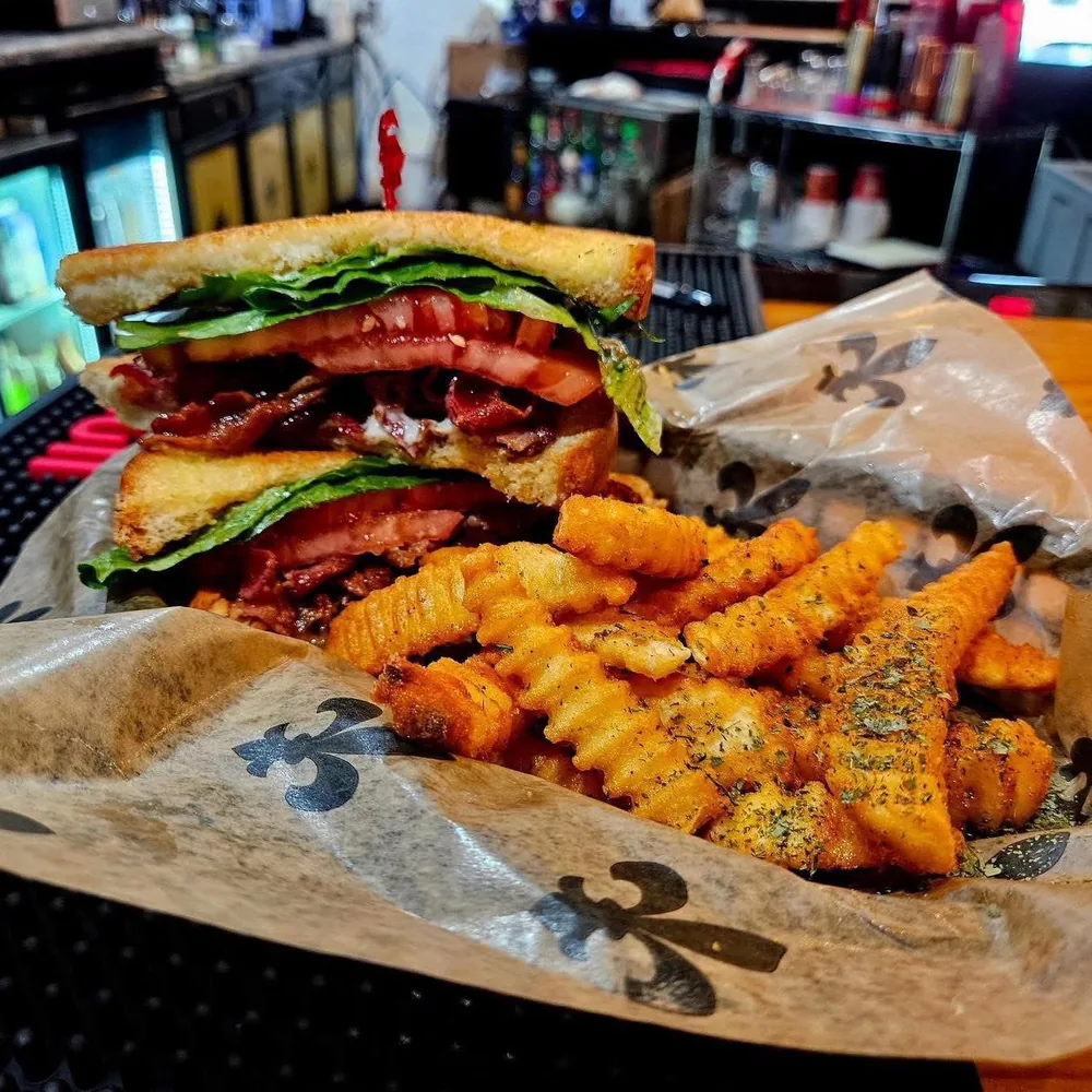 Stacked sandwich with bacon, lettuce and tomato, served with crinkle-cut fries