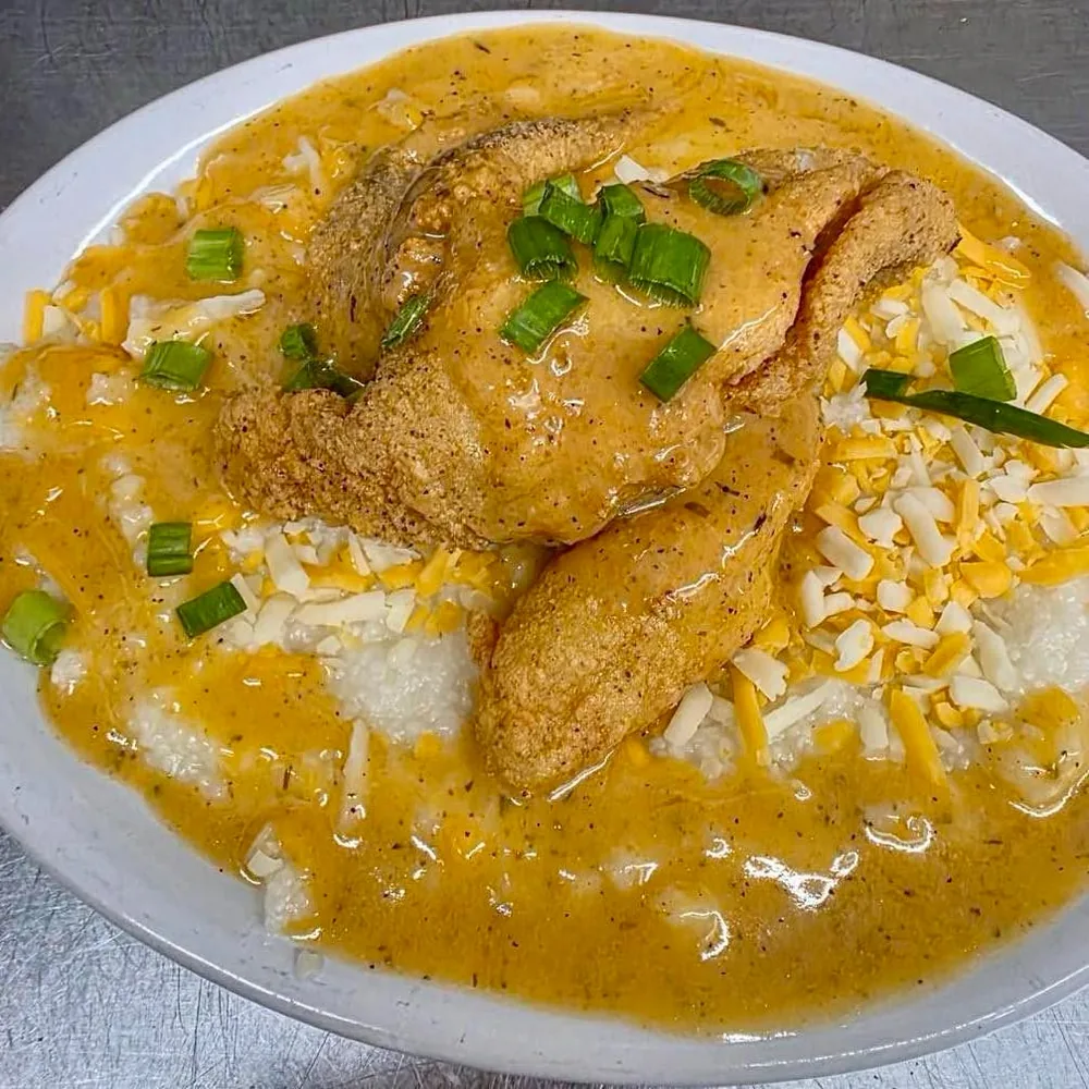 Golden fried fillet over cheesy Cajun grits topped with green onions