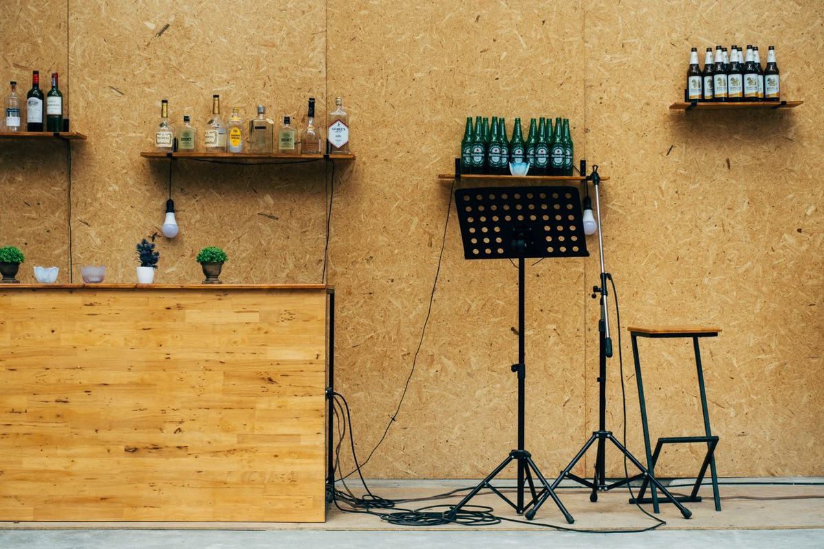 A microphone stand and music stand beside a wooden bar counter