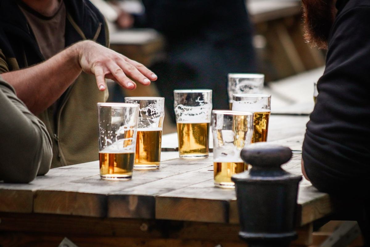 Friends sharing glasses of beer at a wooden table